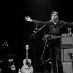 Joel Plaskett passionately performing on stage with guitar